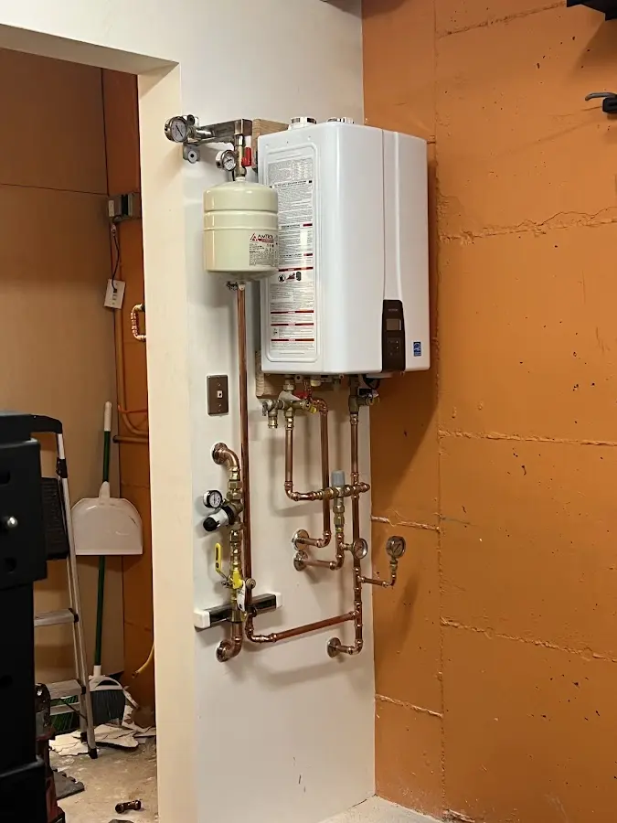 Plumbing technician inspecting water heater connections in East Haddam